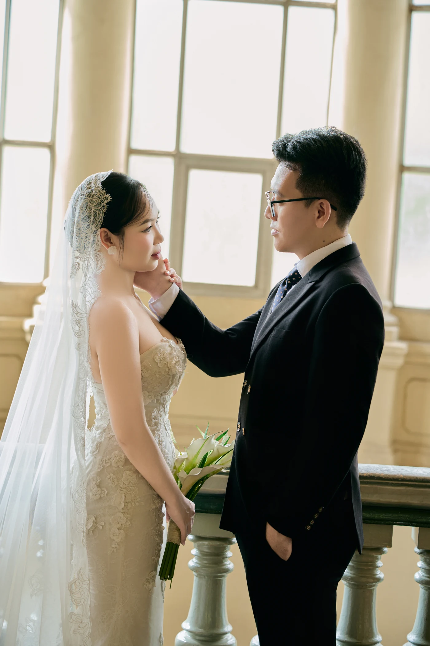 He lifts her chin by the rotunda windows