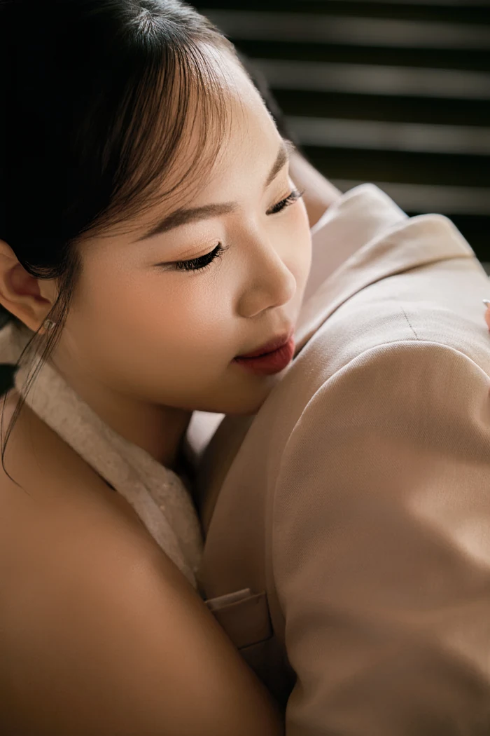 Black and white: her eyes closed, resting against his shoulder